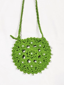 Detailed close-up of grass green hand-crocheted petal bag with white pearl decorations
