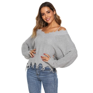 Close-up of distressed V-neck knit sweater featuring shredded hems and raw fringed edges