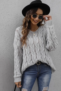 Close-up of light gray chunky cable knit sweater with detailed texture and classic round neck