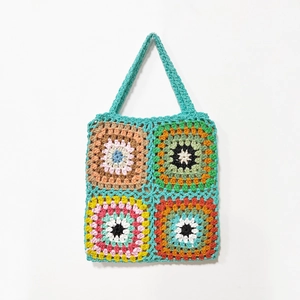 Close-up of handmade crochet tote bag featuring colorful granny square patterns
