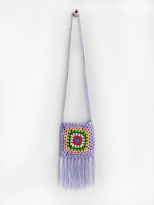 Detail of handmade crochet crossbody bag with colorful granny square and purple tassels