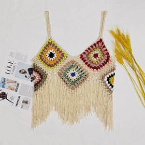 Detail of bohemian crochet crop top featuring colorful granny squares and long fringe
