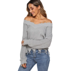 Close-up of distressed fringe hem and hole detailing on grey off-the-shoulder knit sweater