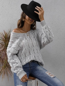 Detailed macro view of the thick cable knit texture on a grey oversized sweater
