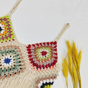 Detailed close-up of handmade crochet camisole with colorful granny square patterns and fringe