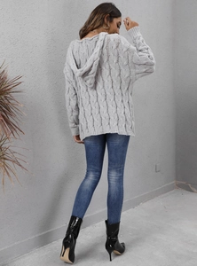 Detail view of thick cable knit texture and large hood on grey oversized sweater