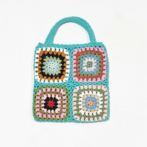 Macro detail of hand-crocheted granny squares on a colorful ethnic style tote bag