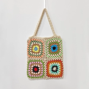 Detailed view of colorful hand-crocheted granny square tote bag with vintage boho texture