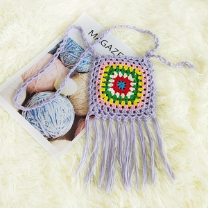 Detail of lavender crochet granny square bag with colorful pattern and long tassels