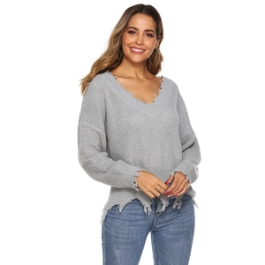 Detail showing distressed V-neck collar and frayed hem on this grey knitted sweater