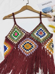 Detailed view of colorful crochet granny square stitching with long bohemian fringe tassels