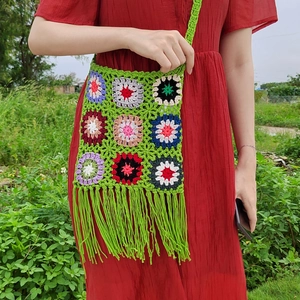 Handmade crochet shoulder bag with colorful floral patchwork and long green tassels