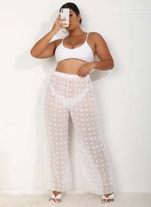 Detalle de conjunto blanco de dos piezas con pantalones anchos transparentes y lunares 3D