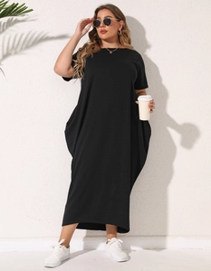 Detail of loose fit black maxi dress featuring side drape pockets and soft cotton fabric