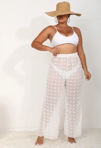 Textura detallada del pantalón playero de gasa blanca con pompones 3D de lunares