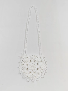 Detail of white handmade crochet round bag with floral knit pattern and pearl beads