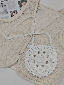 Detailed close-up of handmade crochet bag featuring 3D flowers and pearl beads decoration