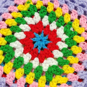 Macro detail showing colorful handmade crochet pattern with floral bohemian textures