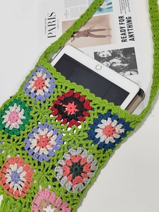 Flat lay showing green crochet tote bag capacity with a tablet on a clean background