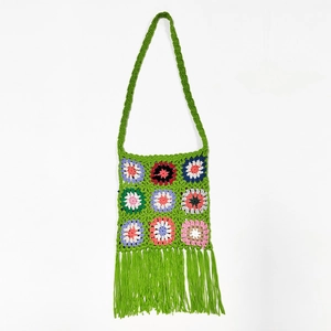 Detail of green handmade crochet shoulder bag featuring colorful granny square patterns