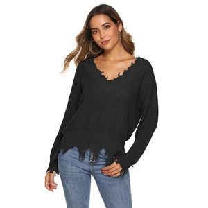 Detail of distressed V-neck and frayed hem on black long-sleeve knit sweater