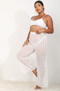 Detalle de pantalón ancho de malla blanca transparente con textura de lunares 3D