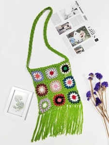 Detailed view of bohemian crochet shoulder bag with colorful floral patterns and green tassels