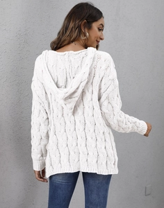 Detail of white chunky cable knit texture and oversized hood on a loose sweater