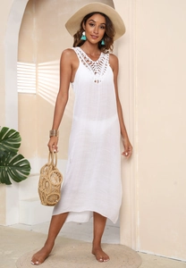 Detail of white beach maxi dress featuring intricate crochet neckline and airy woven fabric