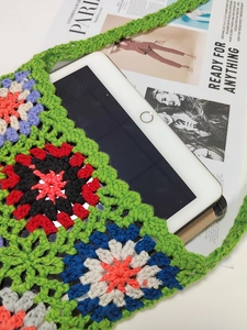 Detail view of large capacity handmade crochet shoulder bag with tablet inside