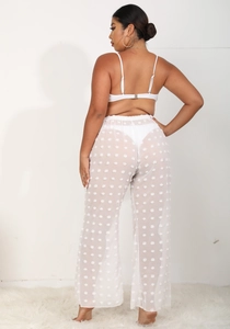 Detalle de pantalones de playa transparentes blancos con textura de pompones 3D en gasa