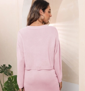 Close-up of soft pink knitted fabric texture on an elegant long-sleeve sweater set