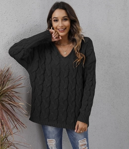 Detail of cable knit pattern and V-neckline on a loose-fitting black hooded sweater