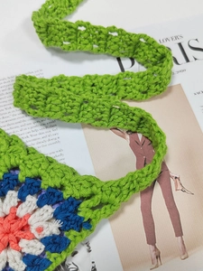 Close-up of bohemian crochet granny square bag with colorful stitching and texture