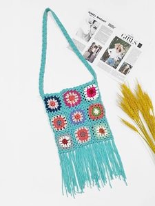 Detail of bohemian handmade crochet bag with colorful floral patterns and long fringes