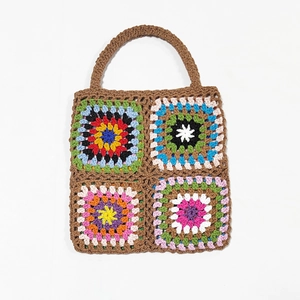 Close-up of handmade crochet granny square handbag with colorful patchwork patterns