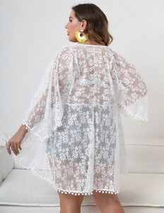 Detail view of sheer white floral lace beach cover-up with delicate pom-pom trim on sleeves