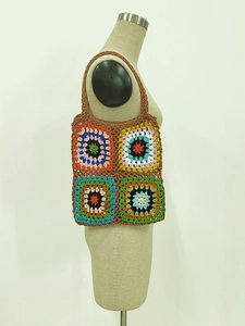 Close-up of handmade crochet granny square bag with colorful bohemian pattern texture