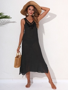 Detail of V-neck crochet lace pattern and hollow texture on a black beach dress