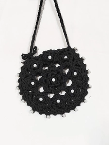 Detail of hand-crocheted black mandala pattern bag with white faux pearl embellishments