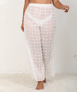 Detalle de pantalones anchos blancos transparentes con pompones 3D y cintura elástica
