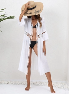 Detail of white lace stitching on a lightweight beach cover-up with round hollow patterns