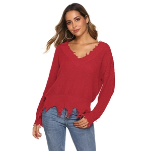 Detail of red V-neck knit sweater featuring distressed frayed edges and loose fringe hem