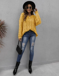 Full body view of women's yellow chunky cable knit sweater with V-neck and loose fit style