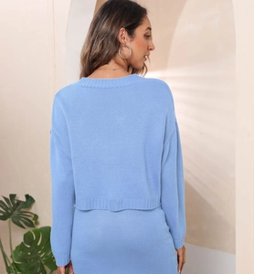 Detailed back view of a light blue jacquard knit cardigan sweater in a cozy interior