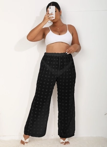 Detalle de los pantalones anchos negros de malla de cintura alta con lunares finos