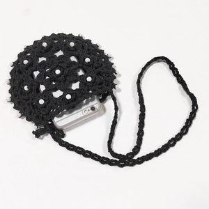 Detail of hand-crocheted ethnic crossbody phone bag with pearls and adjustable strap