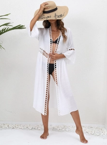 Detailed view of white beach cover-up featuring hollow circle lace trim and lightweight fabric