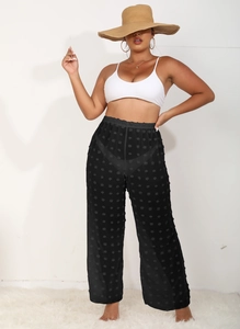 Detalle de pantalones anchos de gasa negra transparente con lunares 3D y cintura elástica