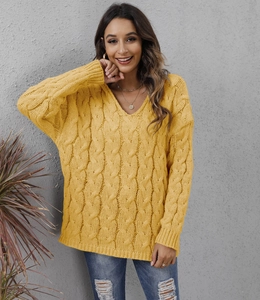 Close-up detail of mustard yellow cable knit sweater with chunky v-neck texture